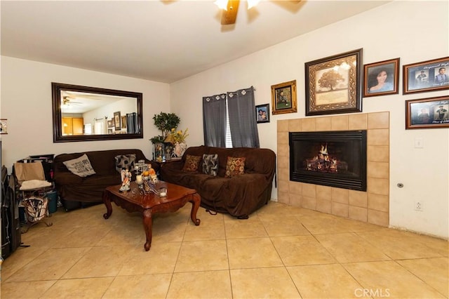 tiled living room with ceiling fan and a fireplace