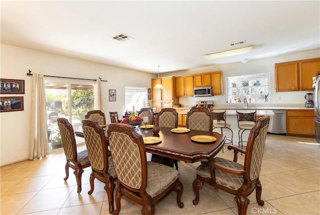 dining space featuring sink and light tile patterned flooring