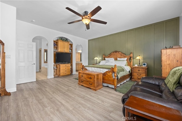 bedroom with ceiling fan, light wood-type flooring, and ensuite bathroom