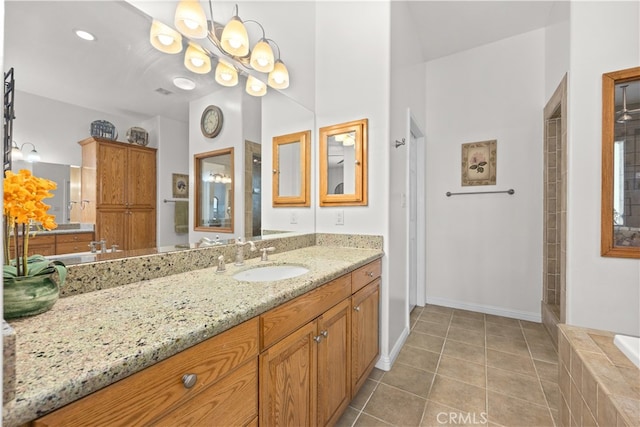 bathroom featuring a relaxing tiled tub, tile patterned flooring, and vanity