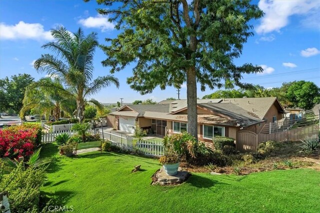 rear view of property with a garage and a lawn