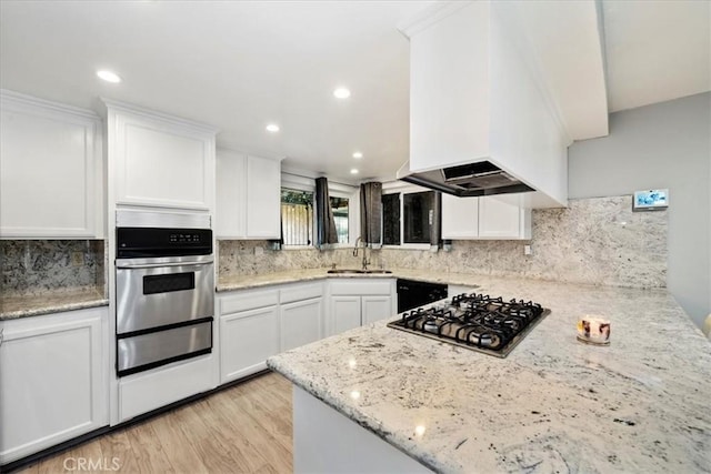 kitchen featuring white cabinets, sink, light stone countertops, light wood-type flooring, and appliances with stainless steel finishes