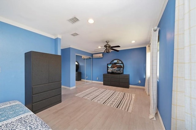 bedroom with a wall mounted air conditioner, ceiling fan, light hardwood / wood-style floors, and crown molding