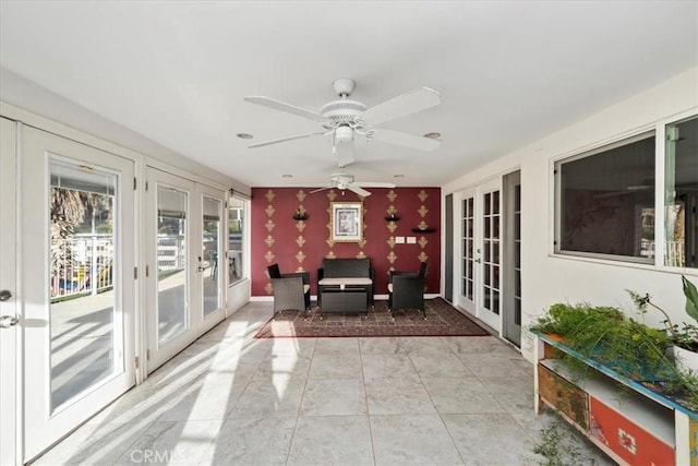 sunroom / solarium with ceiling fan and french doors