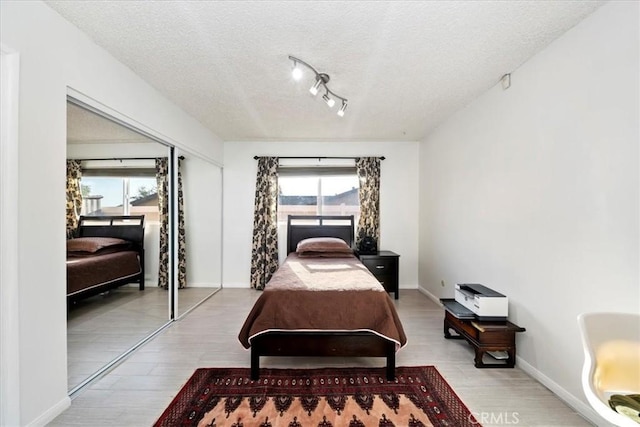 bedroom featuring light wood-type flooring, a textured ceiling, and a closet