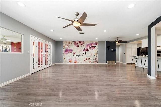 unfurnished living room with hardwood / wood-style floors, ceiling fan, and a healthy amount of sunlight