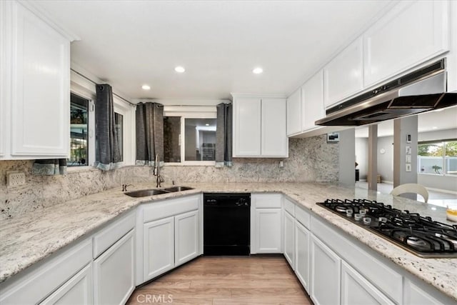 kitchen featuring black appliances, sink, decorative backsplash, light hardwood / wood-style floors, and white cabinetry