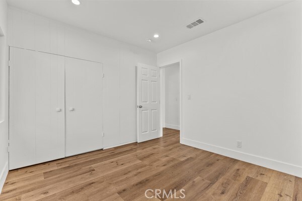 unfurnished bedroom with a closet and light wood-type flooring