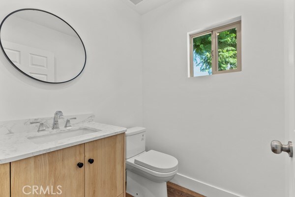 bathroom with vanity, hardwood / wood-style floors, and toilet