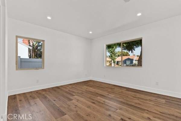 spare room featuring a wealth of natural light and hardwood / wood-style floors