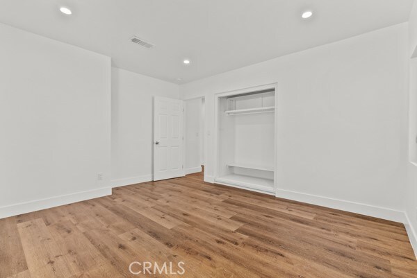 unfurnished bedroom with hardwood / wood-style flooring and a closet