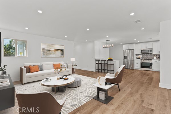 living room featuring an inviting chandelier and light hardwood / wood-style flooring