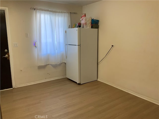 kitchen featuring wood-type flooring and white fridge