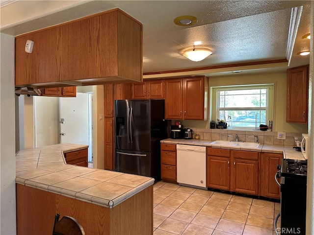 kitchen featuring white dishwasher, black gas stove, kitchen peninsula, sink, and stainless steel fridge with ice dispenser