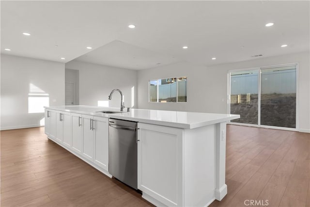 kitchen featuring white cabinets, dishwasher, an island with sink, and sink