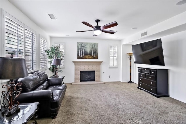 living room featuring a fireplace, carpet, and a healthy amount of sunlight