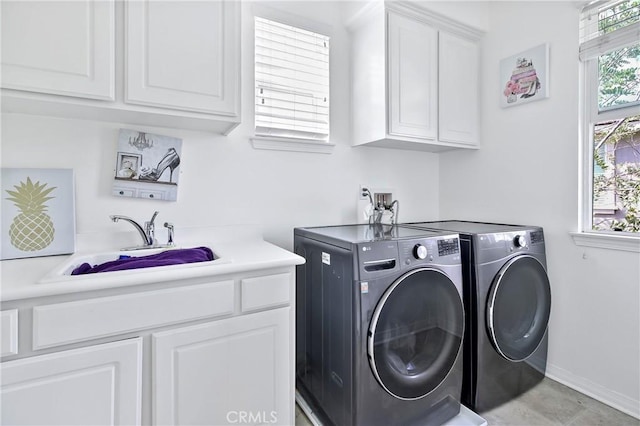 laundry room with cabinets, washer and clothes dryer, and sink