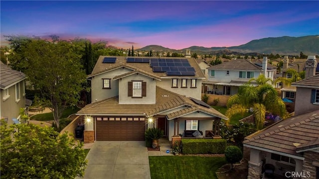 view of front facade with solar panels, a garage, and a mountain view