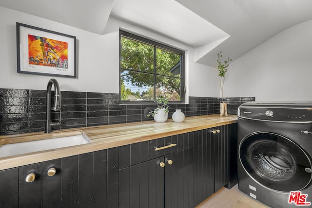 laundry area featuring washer / dryer, cabinets, and sink