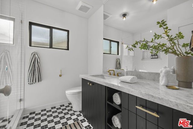 bathroom featuring vanity, toilet, and a shower with shower door