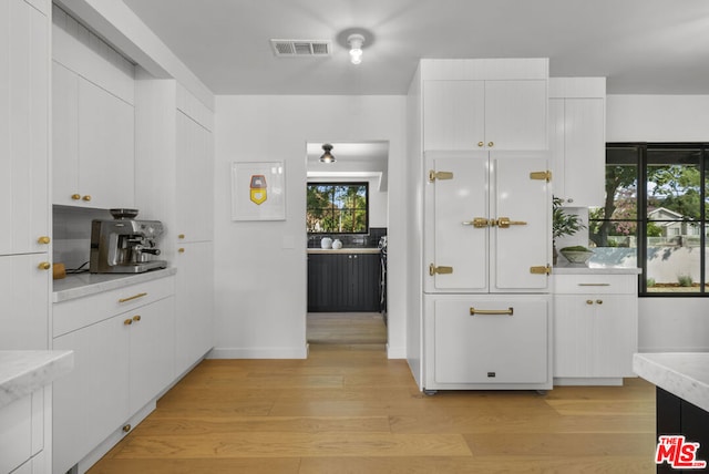 kitchen with white cabinets and light hardwood / wood-style floors