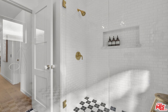 bathroom featuring a shower with door and tile patterned flooring