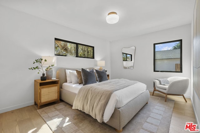 bedroom with multiple windows and light hardwood / wood-style floors