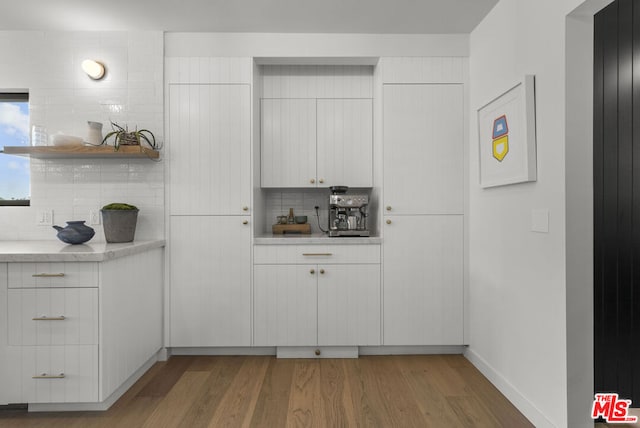 kitchen featuring white cabinetry, decorative backsplash, and dark wood-type flooring