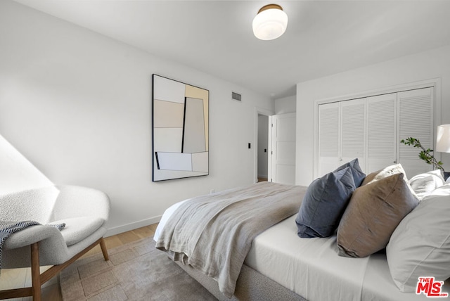 bedroom with a closet and hardwood / wood-style floors