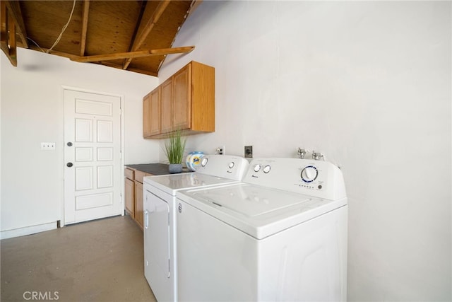 clothes washing area with cabinets and washing machine and clothes dryer