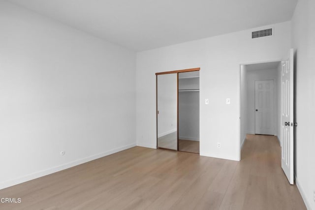 unfurnished bedroom featuring a closet and light hardwood / wood-style floors