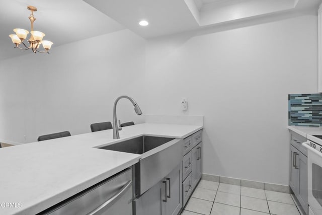 kitchen with pendant lighting, an inviting chandelier, sink, gray cabinets, and tasteful backsplash