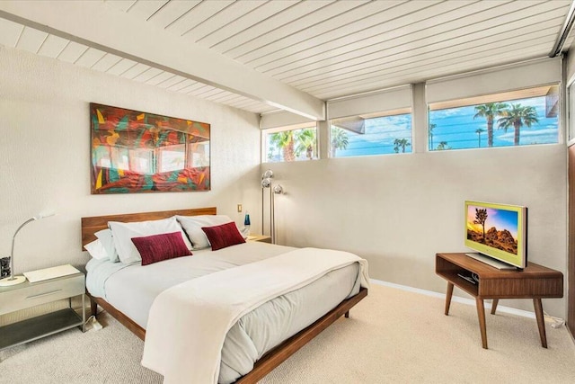 carpeted bedroom with beam ceiling