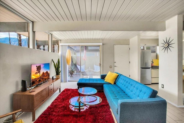 living room with beamed ceiling and light hardwood / wood-style floors