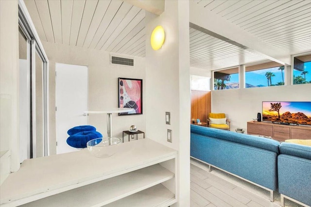 living room with beamed ceiling and light wood-type flooring