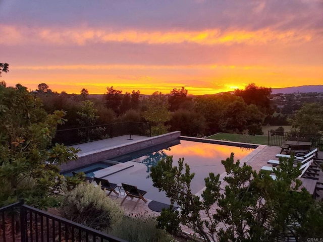 pool at dusk with a patio