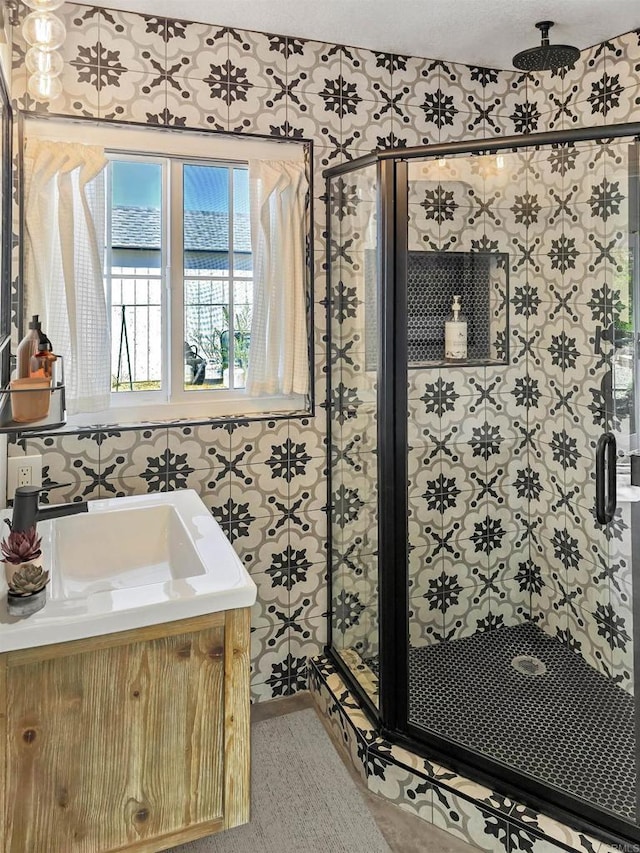 bathroom featuring a textured ceiling, vanity, and walk in shower