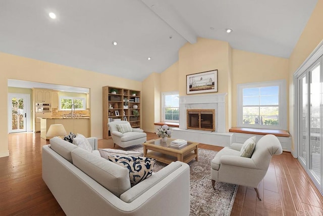 living room with plenty of natural light, light hardwood / wood-style floors, and beam ceiling