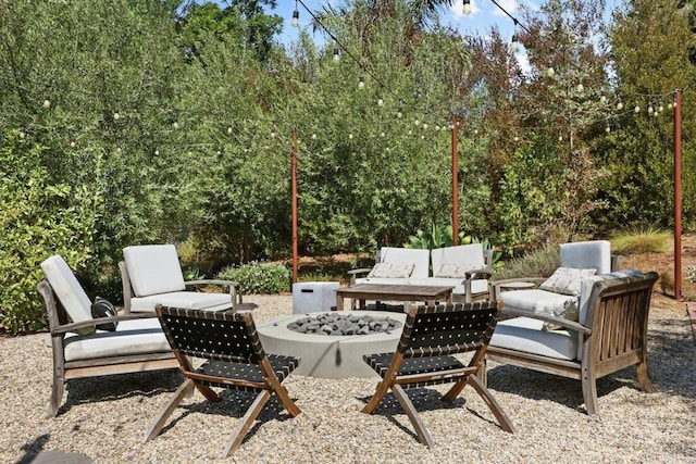 view of patio with an outdoor living space with a fire pit