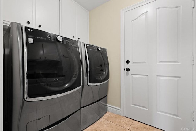 laundry area with light tile patterned floors, cabinets, and independent washer and dryer