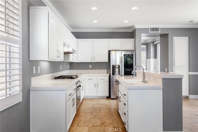 kitchen featuring white cabinets, a center island with sink, and crown molding