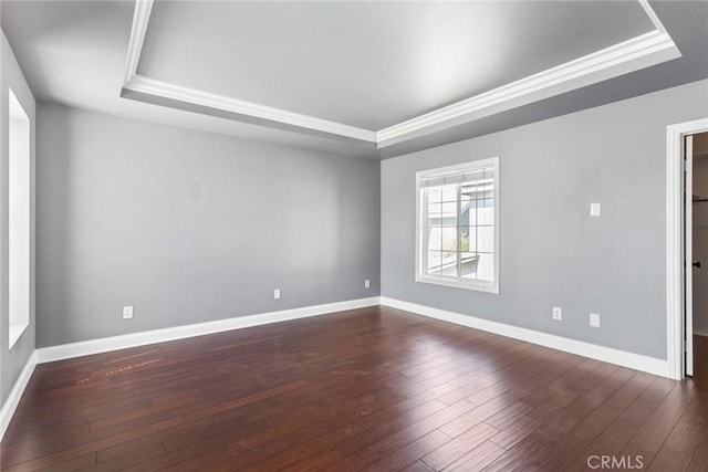 unfurnished room with a tray ceiling and dark wood-type flooring