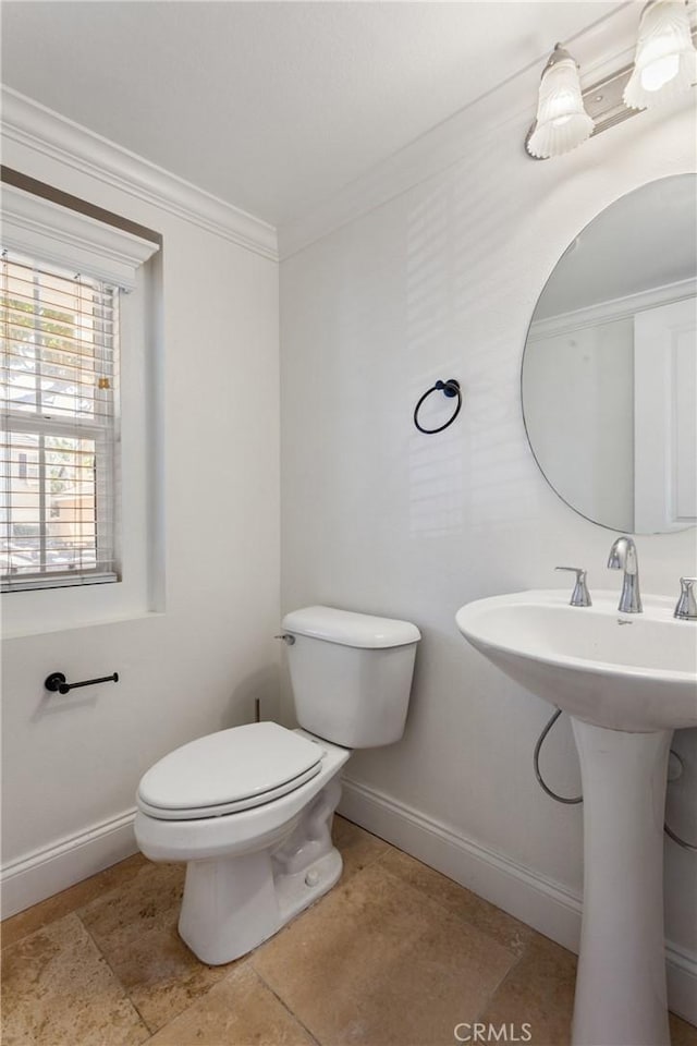 bathroom with crown molding, sink, and toilet