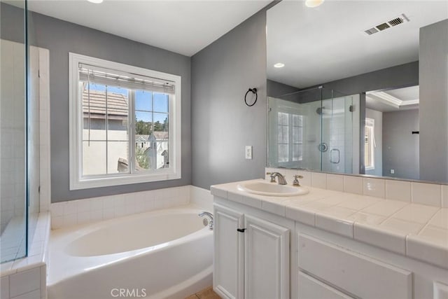 bathroom with vanity and shower with separate bathtub