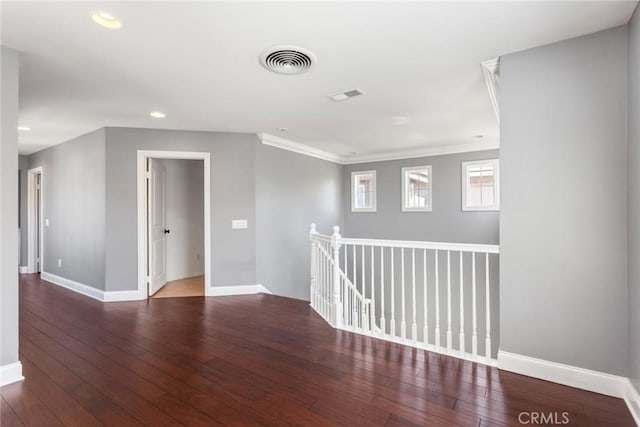 empty room with crown molding and dark wood-type flooring