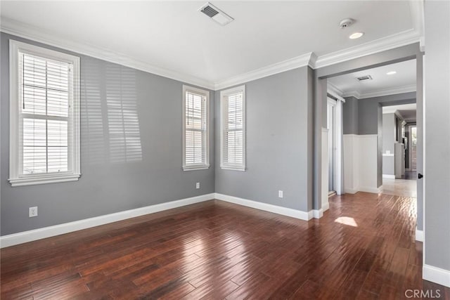 empty room with dark hardwood / wood-style flooring, a healthy amount of sunlight, and ornamental molding