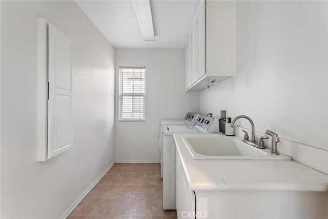 clothes washing area with sink, cabinets, and independent washer and dryer