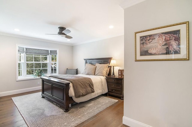 bedroom with recessed lighting, crown molding, baseboards, and wood finished floors