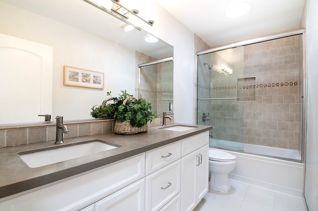 full bathroom featuring bath / shower combo with glass door, vanity, toilet, and tile patterned floors