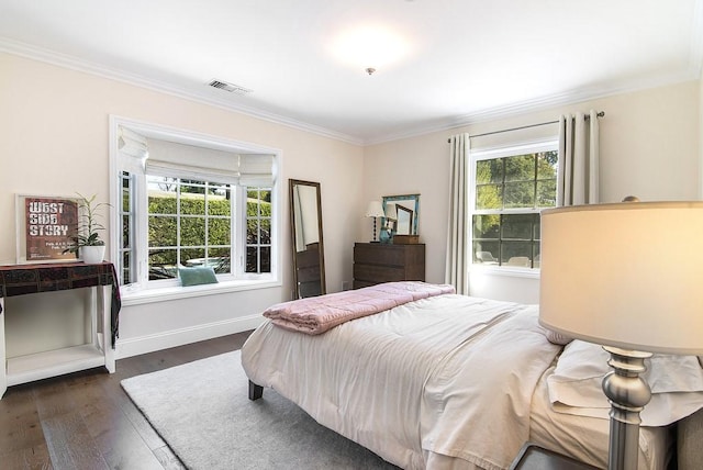 bedroom with dark wood finished floors, baseboards, visible vents, and ornamental molding